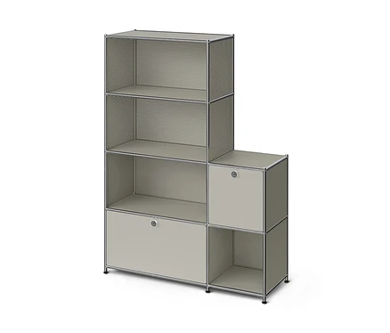 Ein L-förmiges, modulares Regal in Hellgrau mit Chromrahmen. Der höhere linke Teil hat zwei offene Regale mit perforierten Seiten, ein offenes Regal mit massiven Seiten und einen geschlossenen Schrank mit Griff. Der kürzere rechte Teil hat einen geschlossenen Schrank mit Griff und ein offenes Regal darunter.