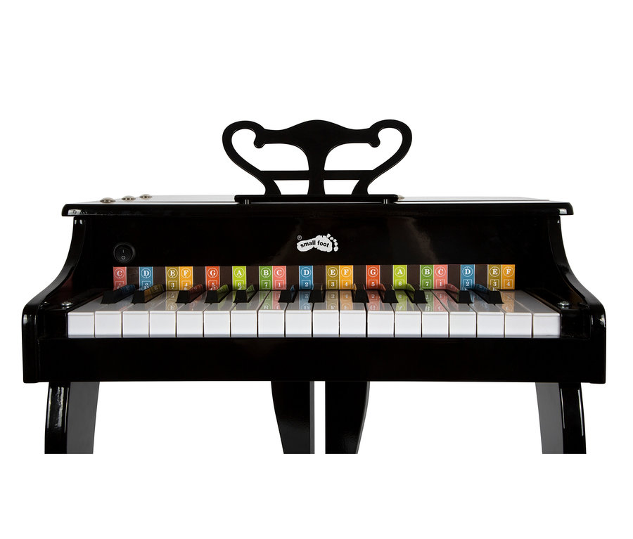 Ein schwarzes Spielzeug-Flügelklavier mit weißen und schwarzen Tasten. Bunte Etiketten mit Buchstaben und Zahlen sind auf den weißen Tasten angebracht. Ein schwarzer, verzierter Notenständer befindet sich hinten, und ein „small foot“-Logo ist über den Tasten sichtbar.