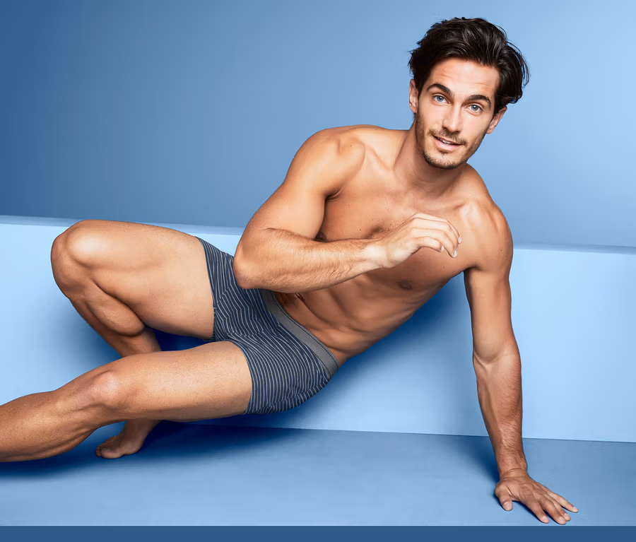 Mann posiert vor blauem Hintergrund in 2 Slipboxer.