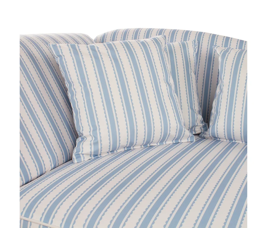 Sofa mit hellblau-weiß gestreiftem Stoffbezug und passenden Kissen. Die blauen Streifen haben einen wellenförmigen Rand.