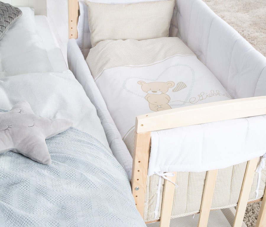 Ein roba 4-in-1-Stuben-Beistellbett »Liebhabär« steht neben einem Bett.