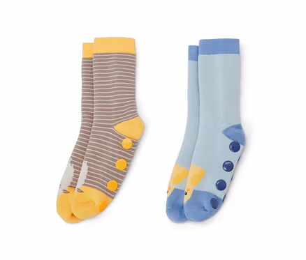 Zwei Paar Kinder-Antirutsch-Socken. Ein Paar ist braun-weiß gestreift mit gelben Akzenten und Vogelbild, das andere Paar ist hellblau mit Giraffenbild und dunkelblauen Punkten.