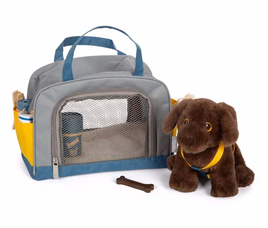 Ein brauner Plüschhund sitzt neben einer grauen Tasche mit blauen Details und einem braunen Knochen.