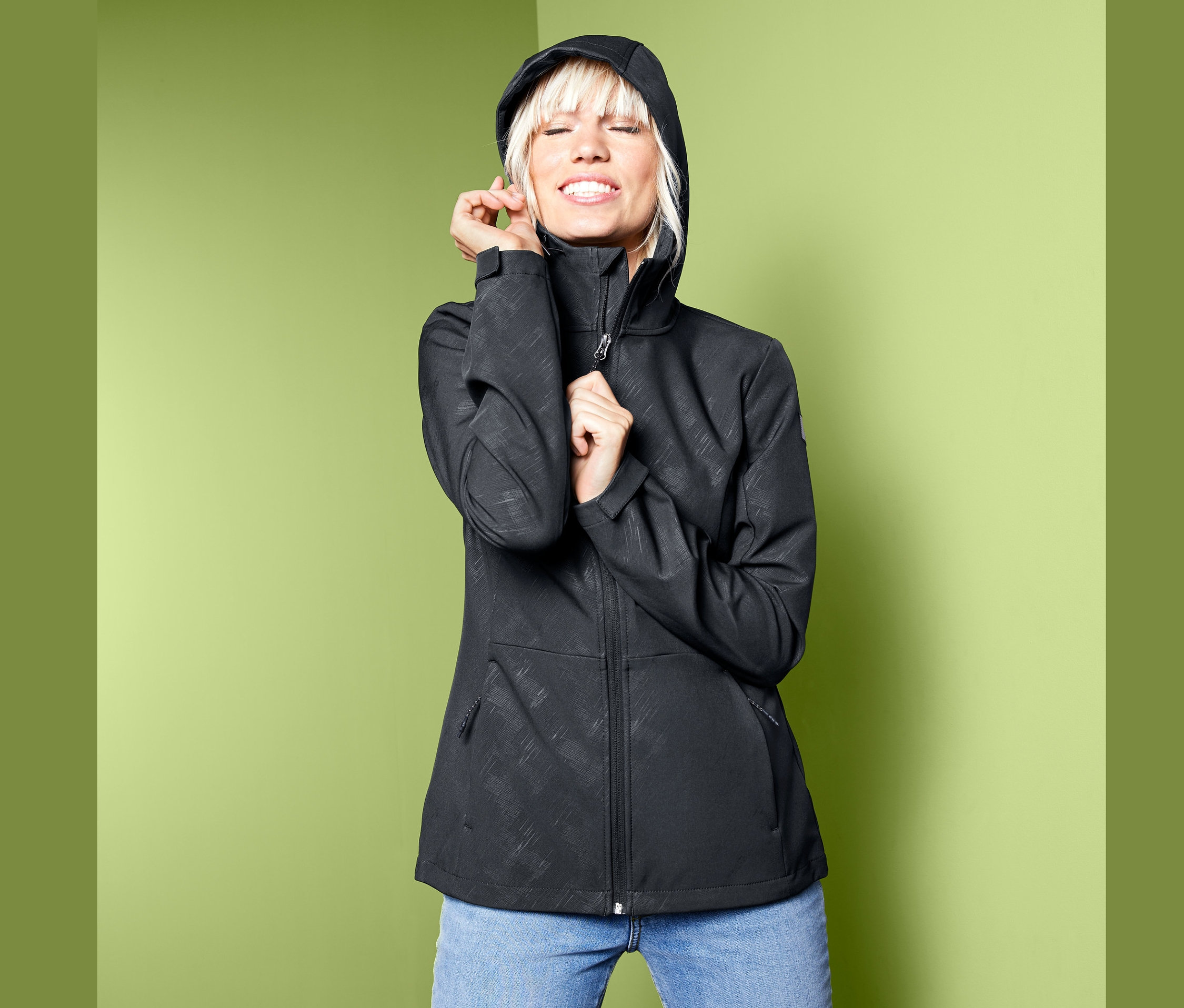 Frau posiert in Softshelljacke.