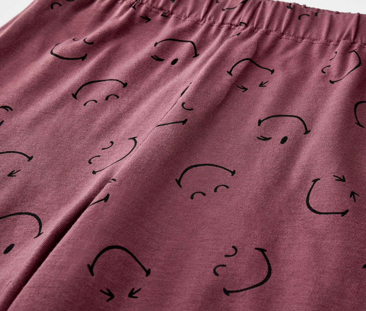 Detailaufnahme eines Kinder-Pyjamas von SMILEYWORLD® mit Gesichtsmuster.