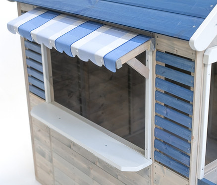 Detailansicht eines Wendi-Spielhauses »Maritime House« mit blauem Dach und gestreifter Markise.