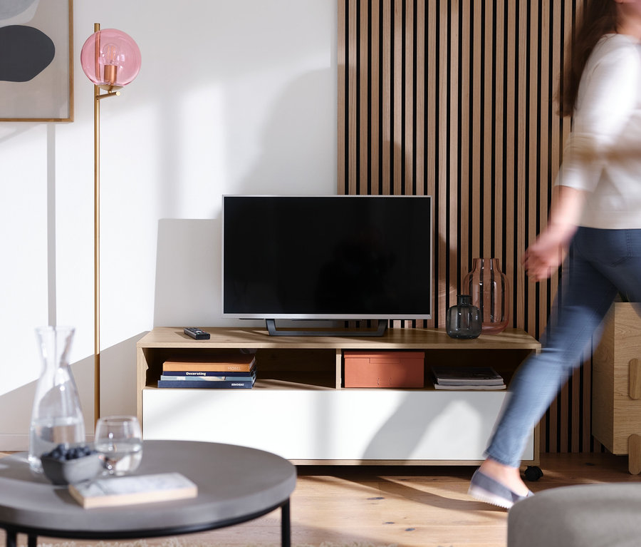 Wohnzimmer mit Stehleuchte »Glaskugel« und TV-Board mit Rollen.