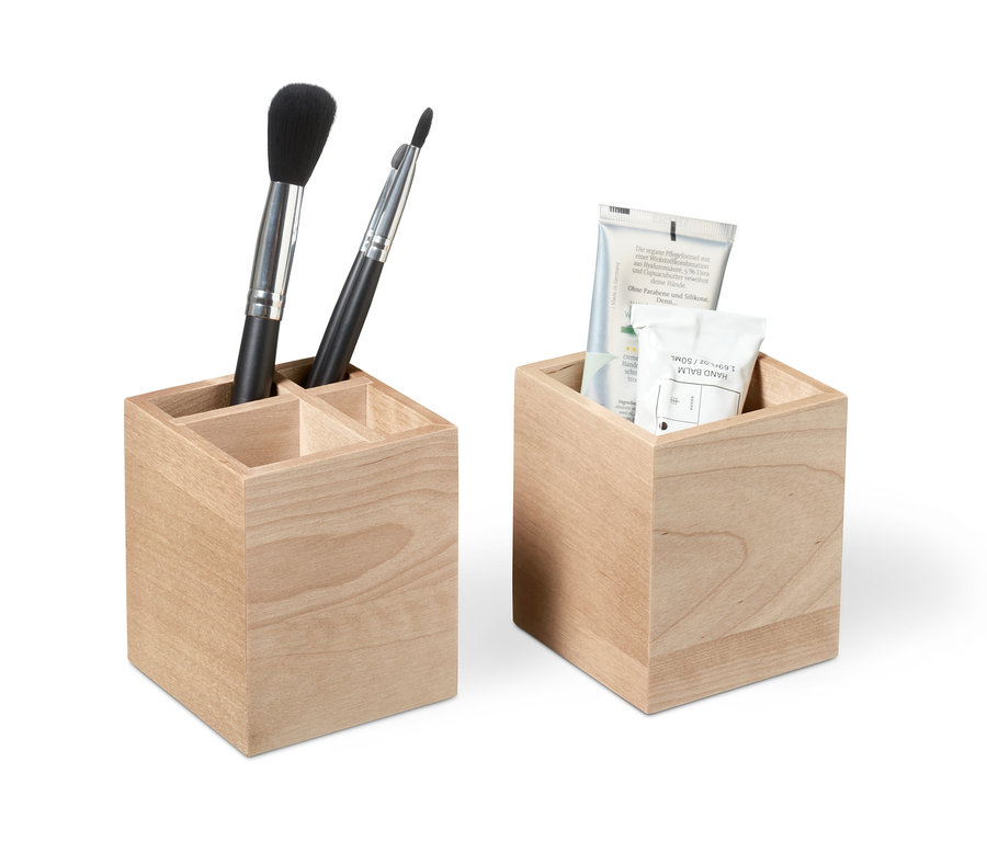 Zwei hölzerne Ordnungsboxen, eine mit Kosmetikpinseln und die andere mit Cremetuben.