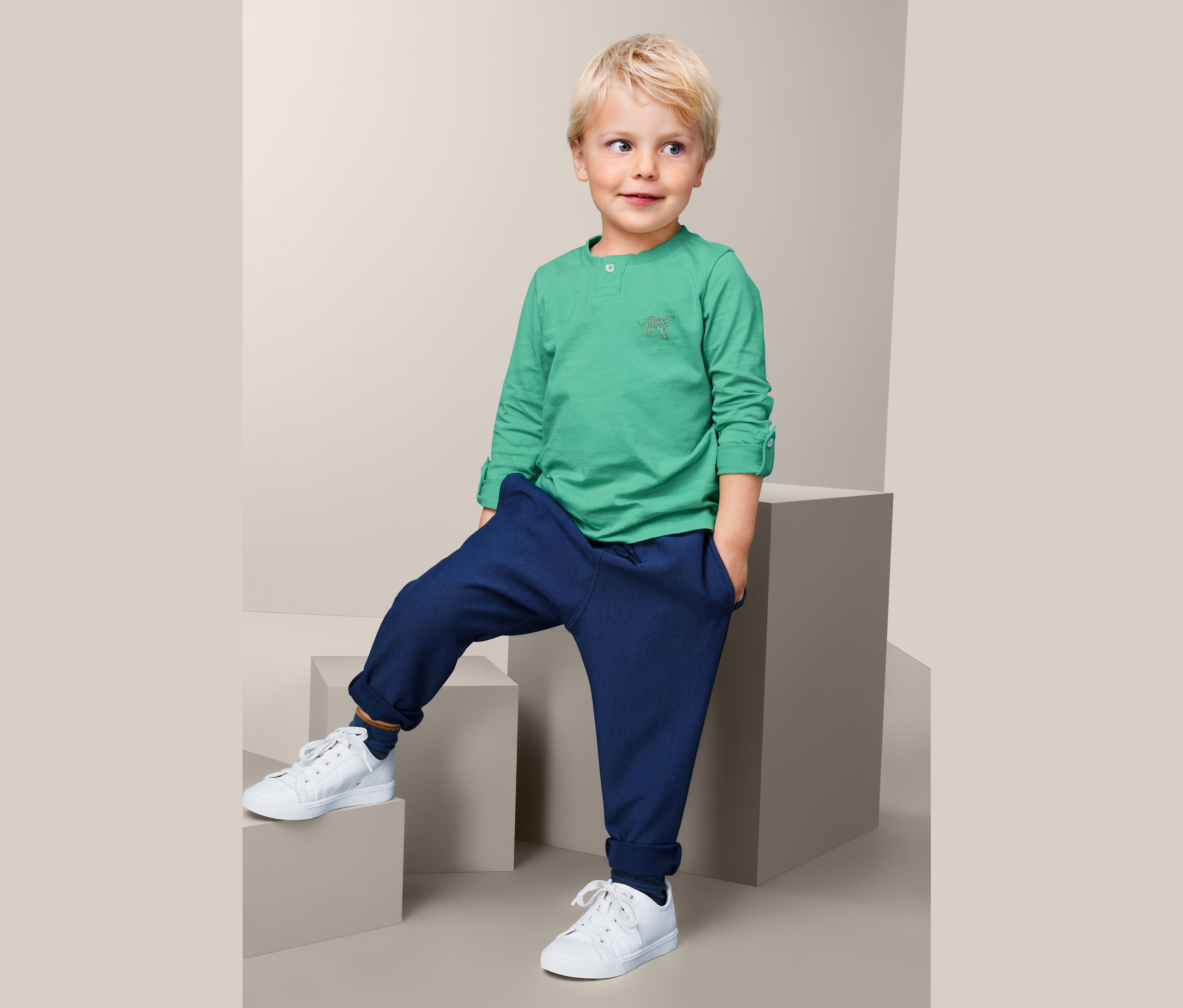 Junge posiert in Baumwoll-Langarmshirt auf Treppe.