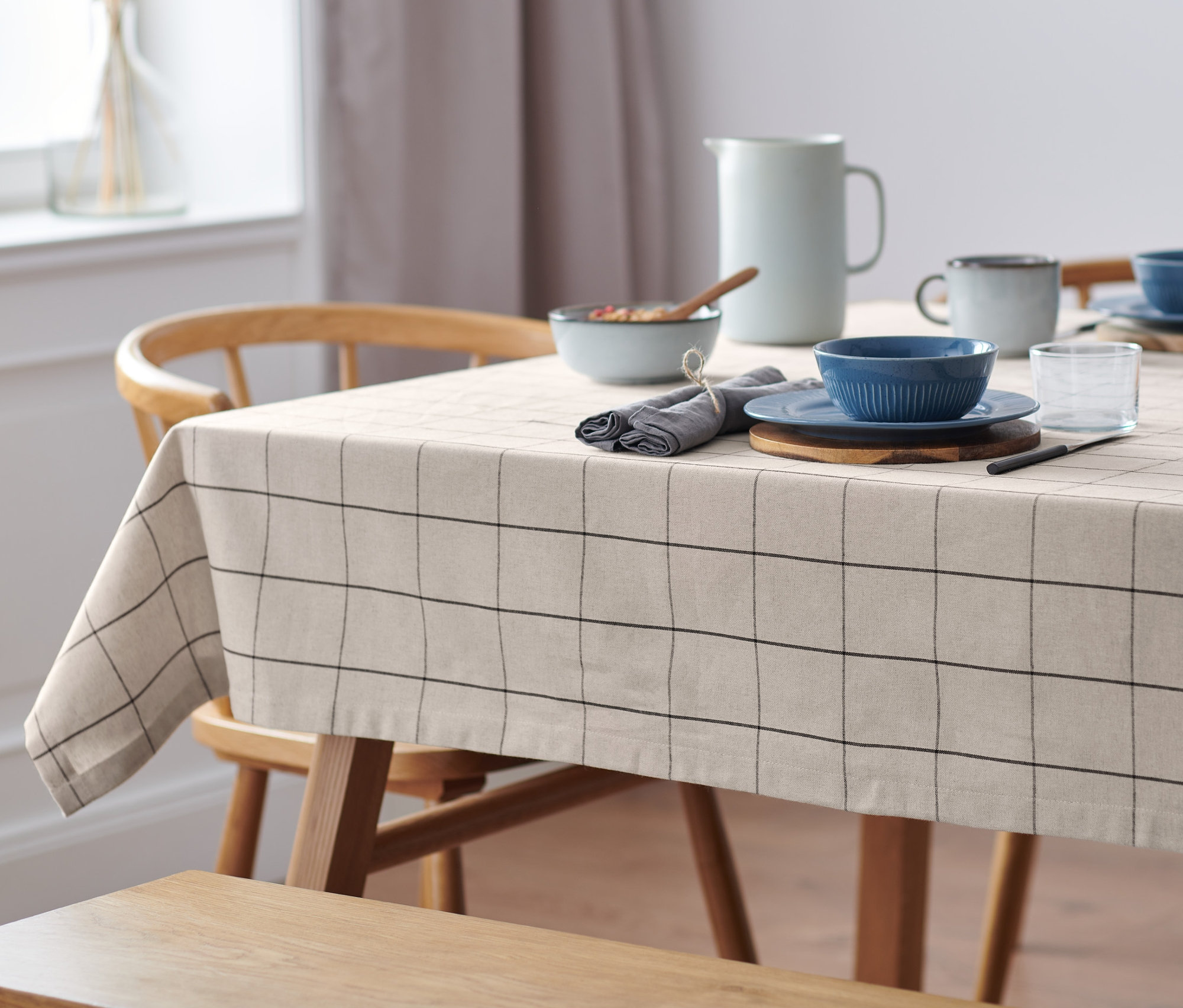 Gedeckter Tisch mit karierter Tischdecke.