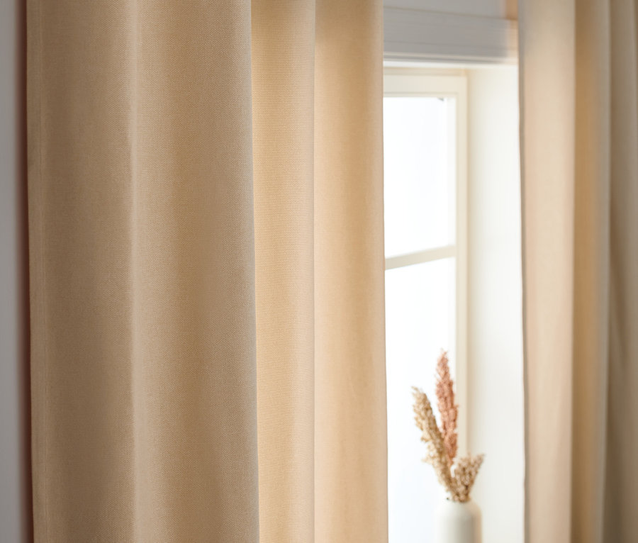 Beige Vorhangschals verdecken ein Fenster.