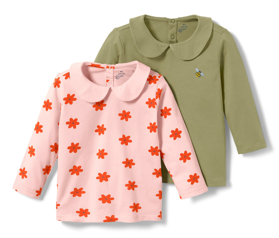 Zwei Baby-Shirts, eins rosa mit roten Blumen, eins grün mit gestickter Biene.