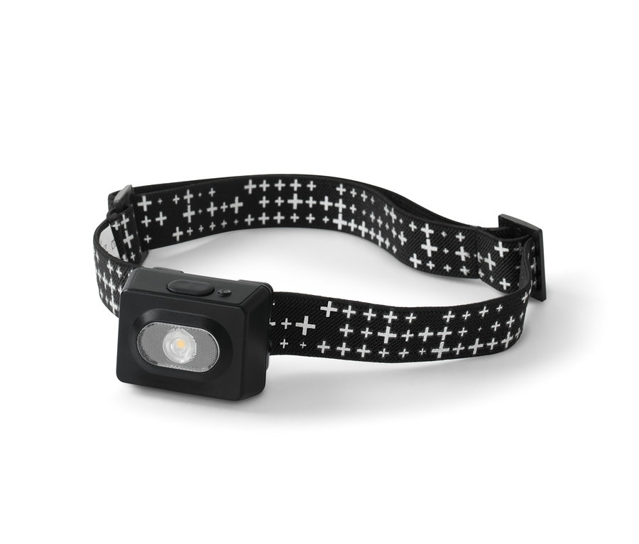 Eine Stirnlampe mit einem schwarzen Gehäuse und einem schwarzen Stirnband mit einem weißen Kreuzmuster.