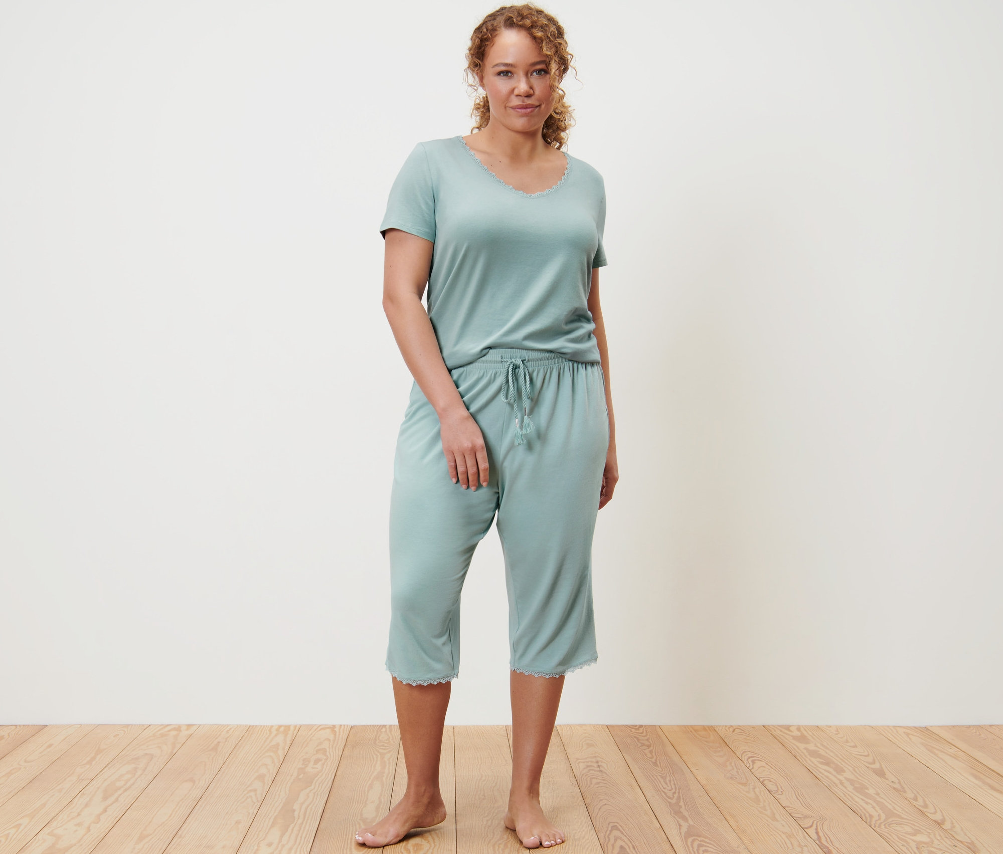 Eine Frau steht und trägt einen hellblauen 3/4-Pyjama.