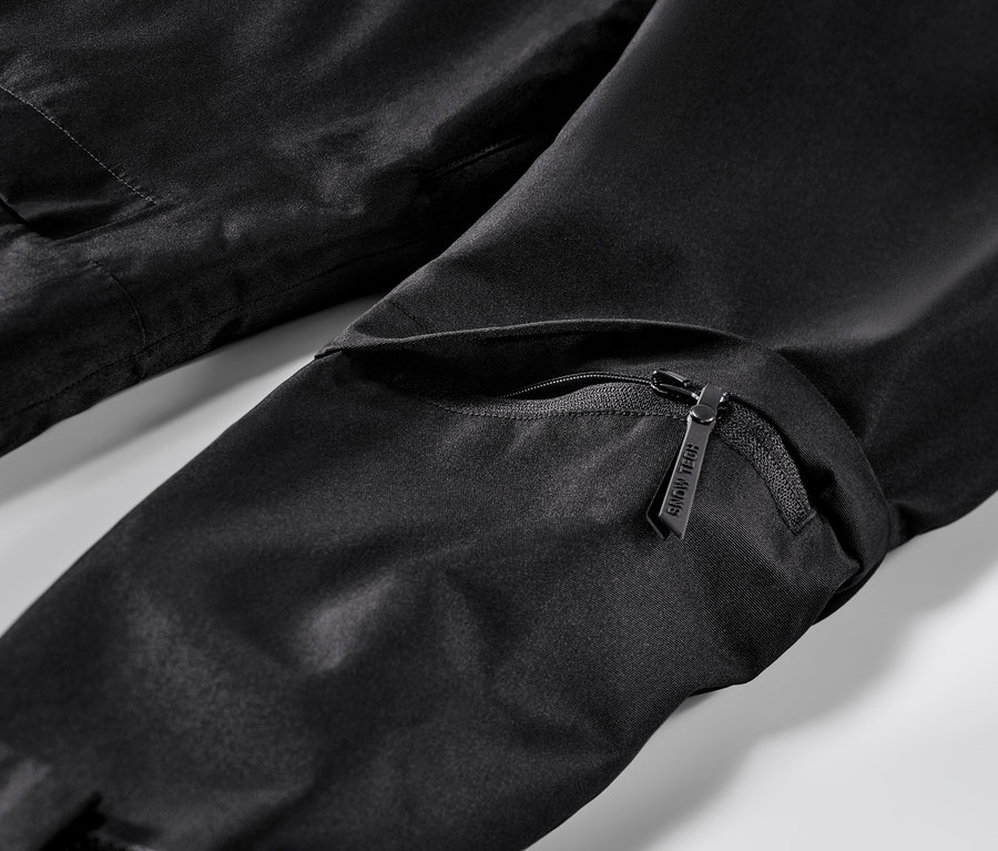 Detailansicht einer schwarzen Skijacke mit Reißverschluss und Tasche.