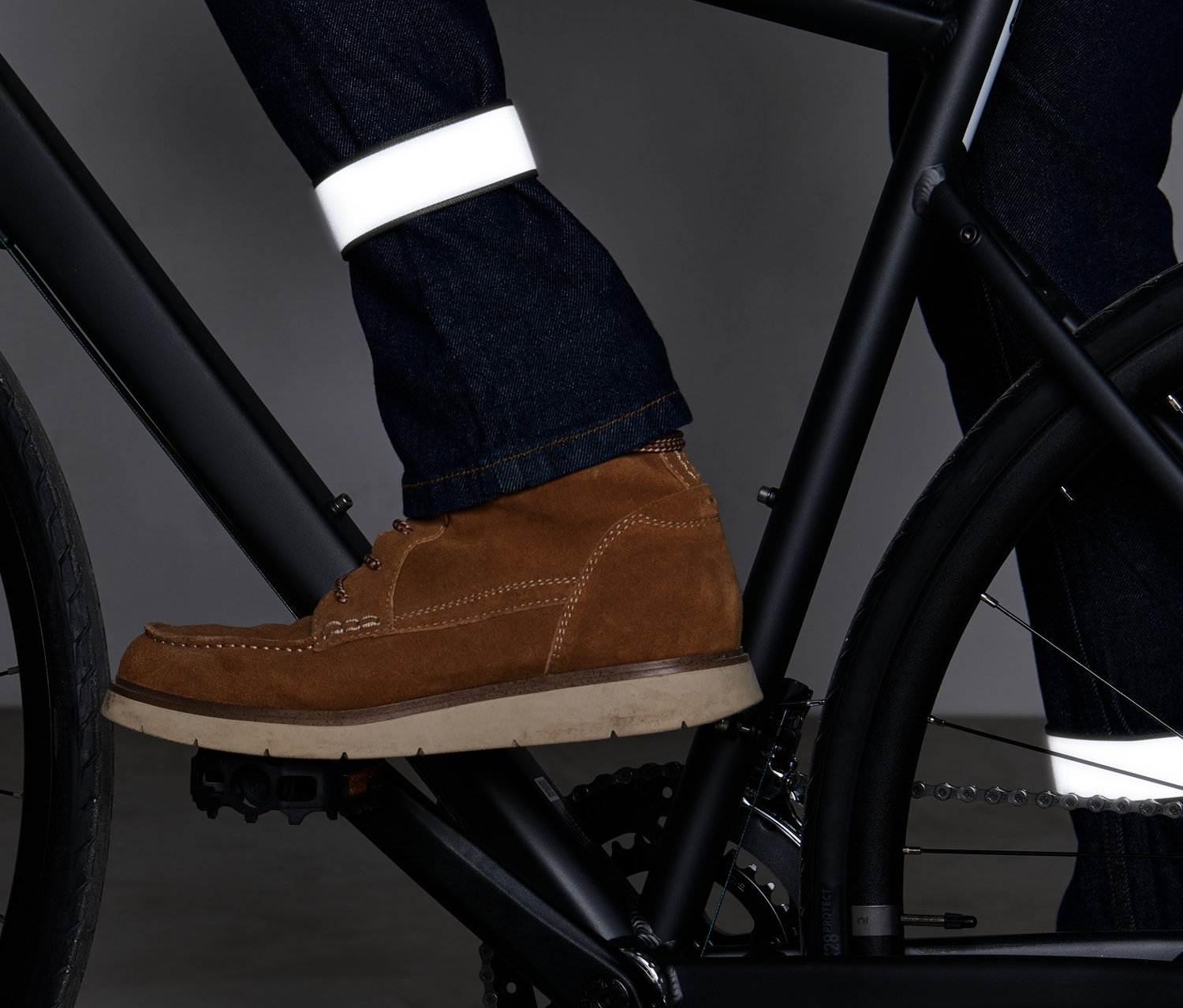 Radfahrer mit 2 Reflektor-Hosenbändern an den Hosenbeinen.