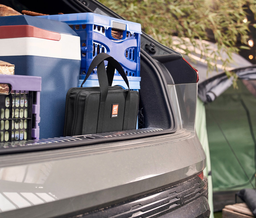 Im Kofferraum befinden sich eine Kühlbox, Getränkekisten und ein ZWILLING Messer-Traveller-Set.