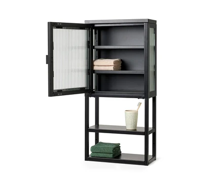 Schwarzer Wandschrank mit Glastür, Handtüchern und Becher mit Zahnbürste.