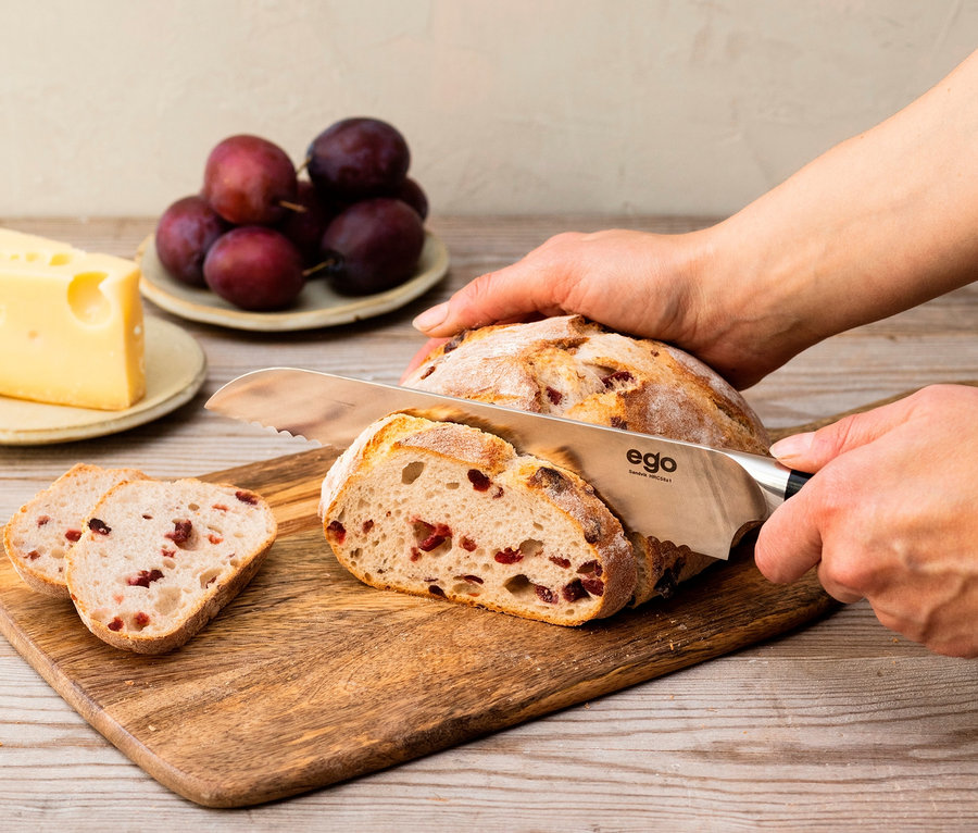 Eine Person schneidet mit einem WILFA Brotmesser EGO Sandvik Cranberry-Brot.