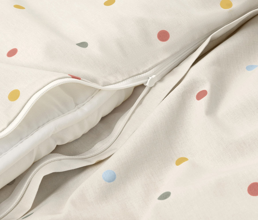 Detailansicht von Kinder-Renforcé-Bettwäsche mit bunten Punkten und Reißverschluss.
