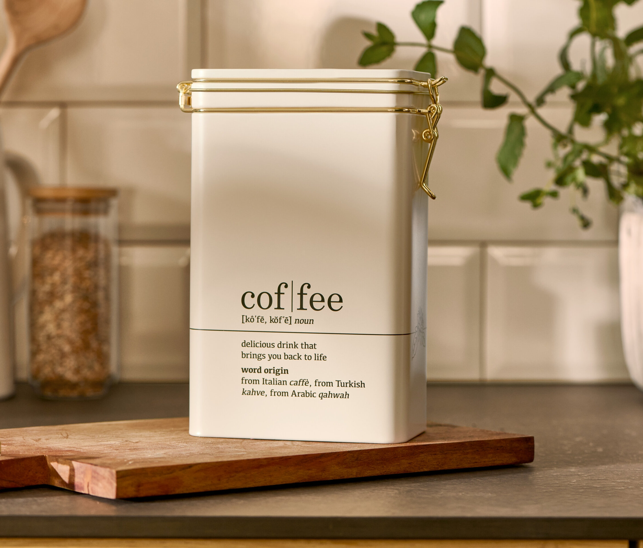 Eine weiße Kaffeedose, Coffee Dictionary steht auf einem Holzbrett.