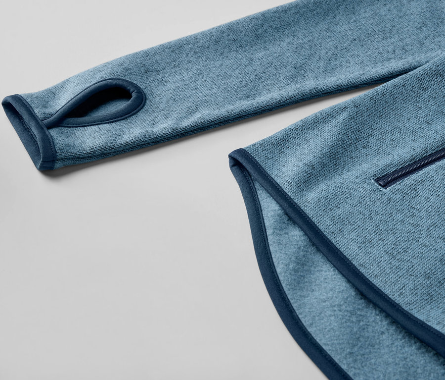 Detailansicht einer dunkelblauen Strickfleece-Jacke mit Daumenloch.