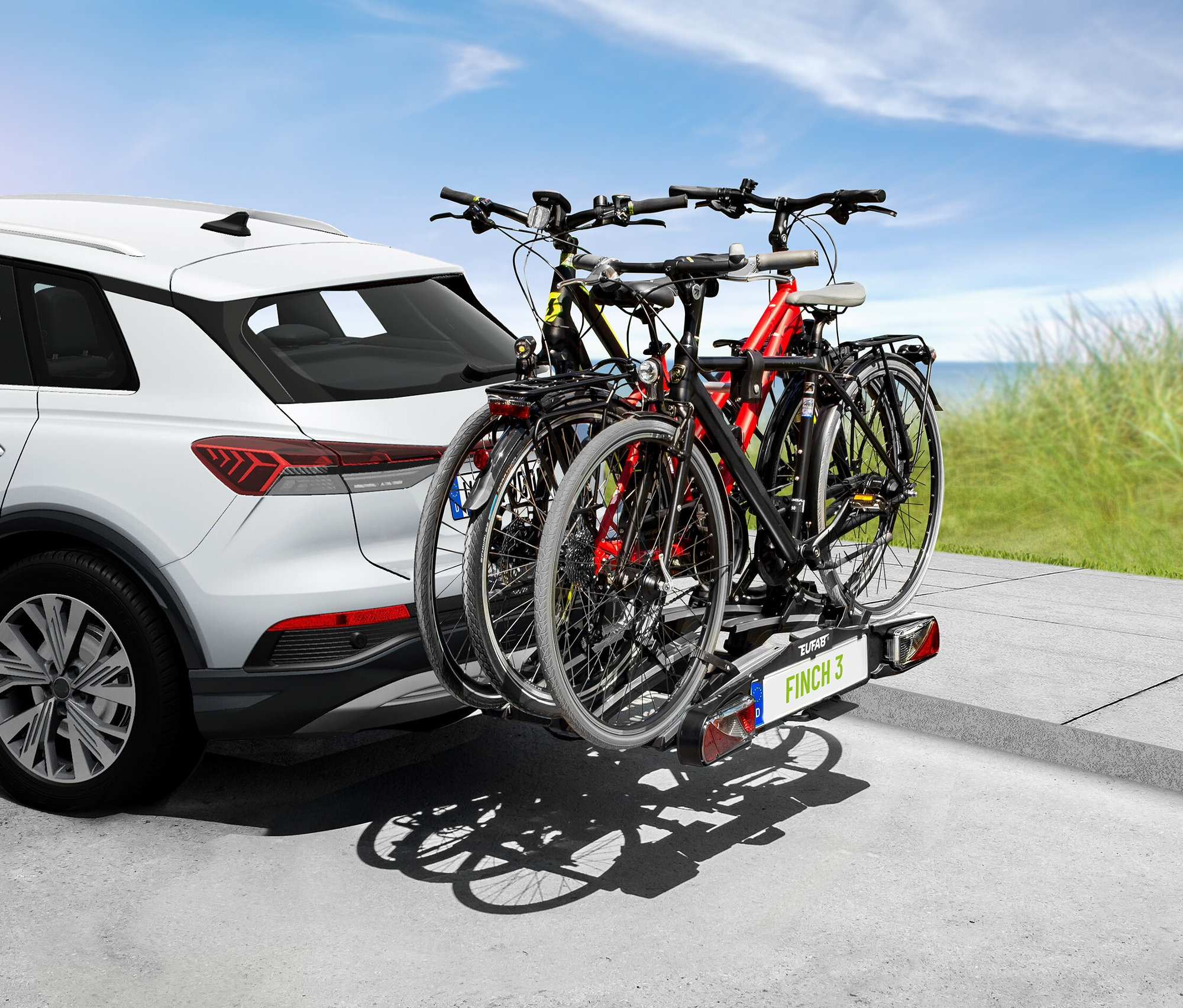 Auf einem weißen Auto ist ein EAL Fahrradträger »FINCH« für 3 Fahrräder montiert.