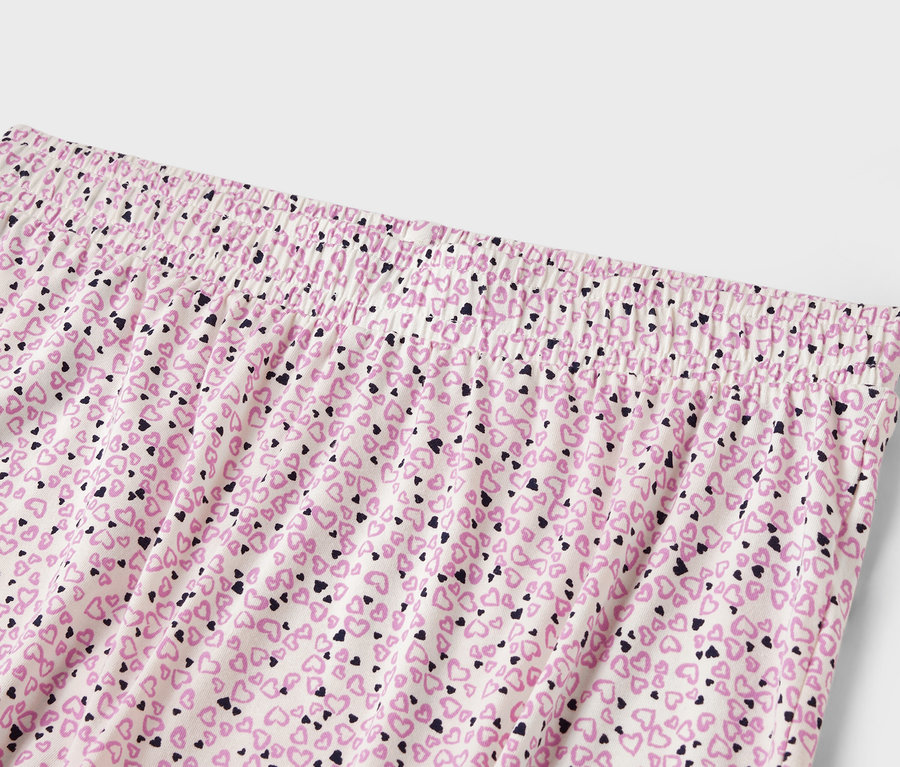 Detail einer Damenhose mit Gummibund und einem Allover-Druck aus kleinen Herzen.