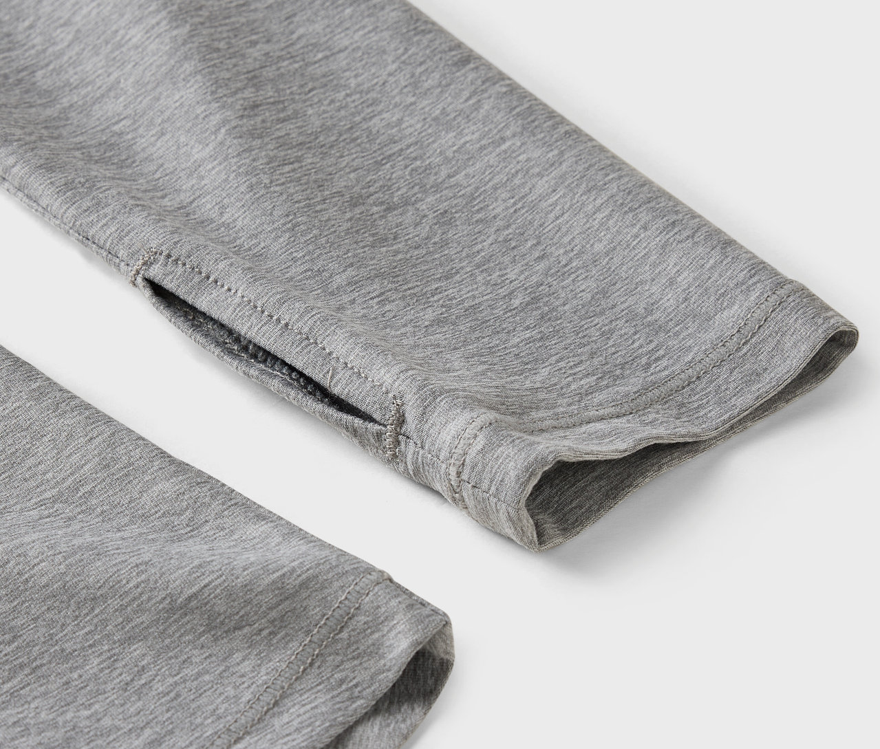 Detail eines grauen Ärmels mit Daumenloch.