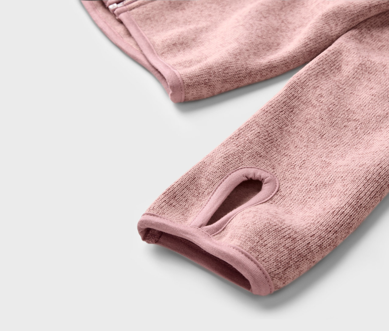 Detailaufnahme einer Kinder-Strickfleecejacke mit Daumenloch.