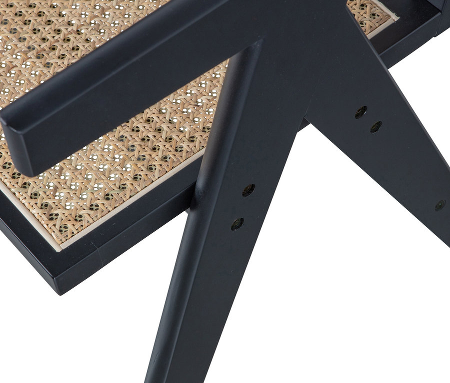 Detailaufnahme eines schwarzen Woood Gunn Esszimmerstuhls mit Rattansitz.