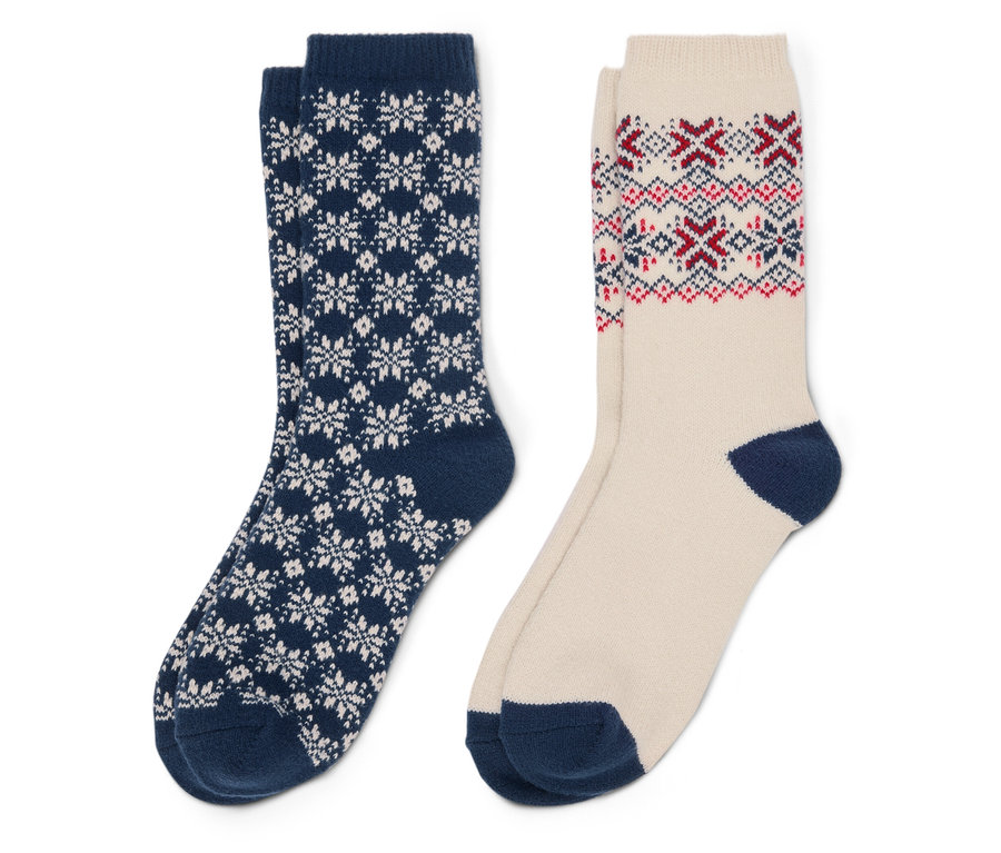 Zwei Socken: eine marineblaue Socke mit weißen Schneeflocken und eine beige Socke mit roten und blauen Mustern.