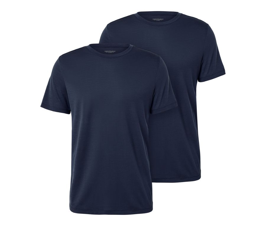 Mann sitzt auf einem Hocker und trägt ein blaues T-Shirt mit Merinowolle aus einem 2er-Set.