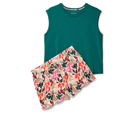 Ein grünes Tanktop und Shorts mit Blattmuster liegen auf einem weißen Hintergrund.