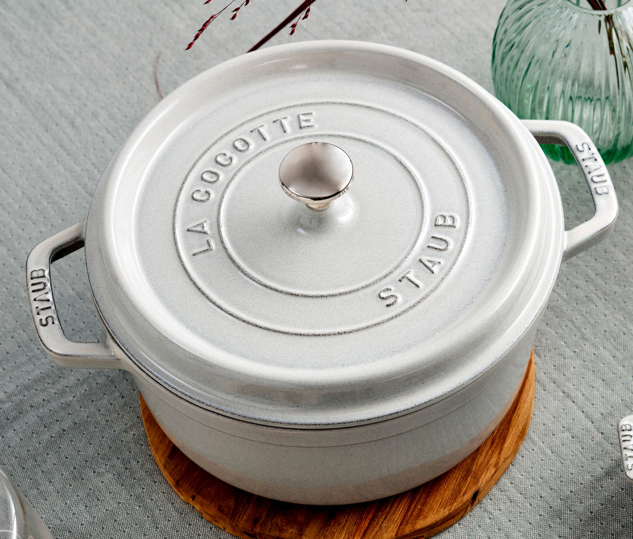 Ein weißer STAUB »Cocotte 24« Topf (ca. 3,7 l) steht auf einem Holzteller.