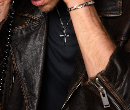 Mann mit brauner Lederjacke und Amor Unisex-Halsschmuck mit Kreuz-Anhänger.