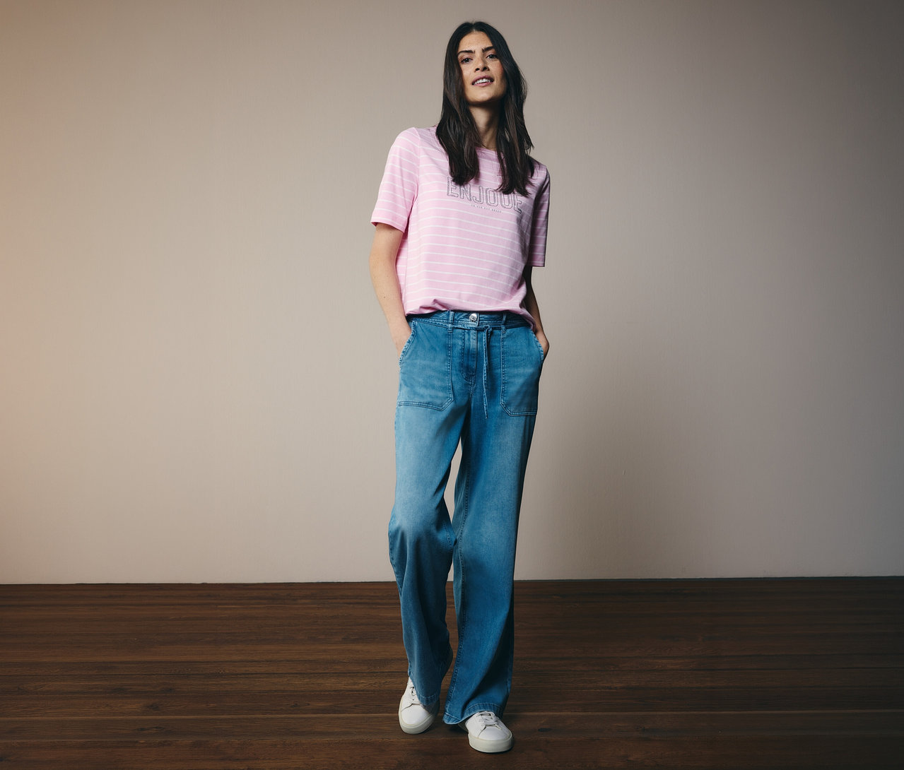 Frau in geringeltem Shirt und CECIL Jeans »Neele« mit Händen in den Hosentaschen.