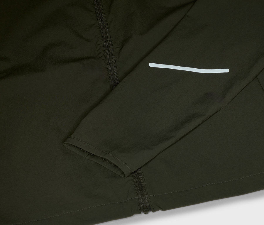 Detailansicht einer olivgrünen Jacke mit Reißverschluss und reflektierendem Streifen am Ärmel.
