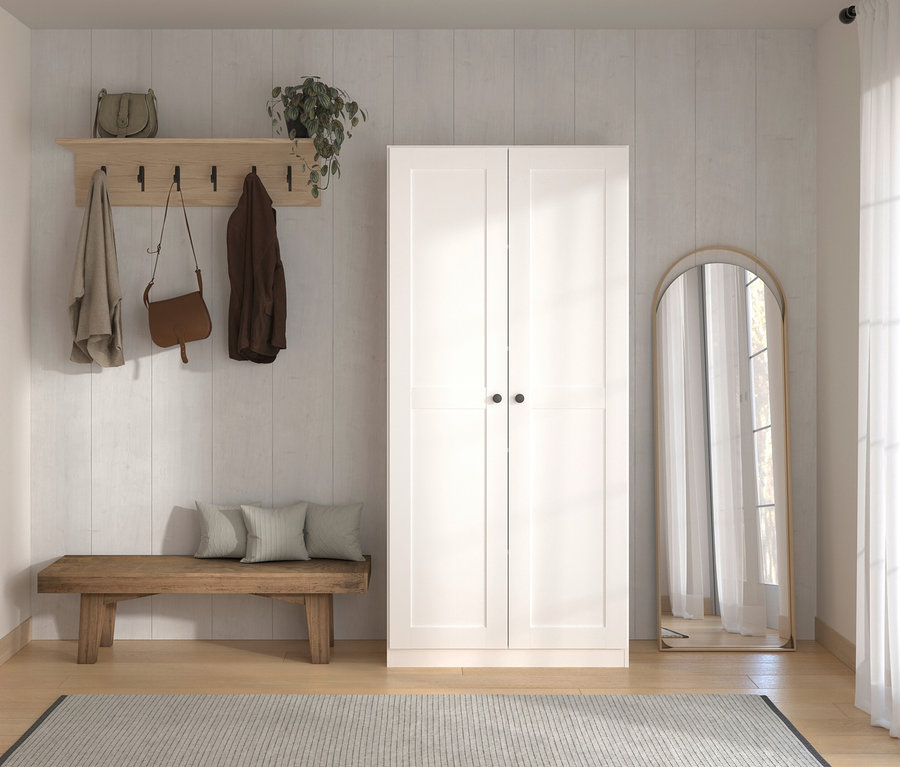 Flur mit Garderobe, Holzbänken, Kissen, weißem Schrank und Spiegel. An der Garderobe hängen eine Tasche und Jacken.