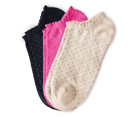 Drei Paar Socken, marineblau, pink und beige mit kleinen Punkten liegen übereinander.