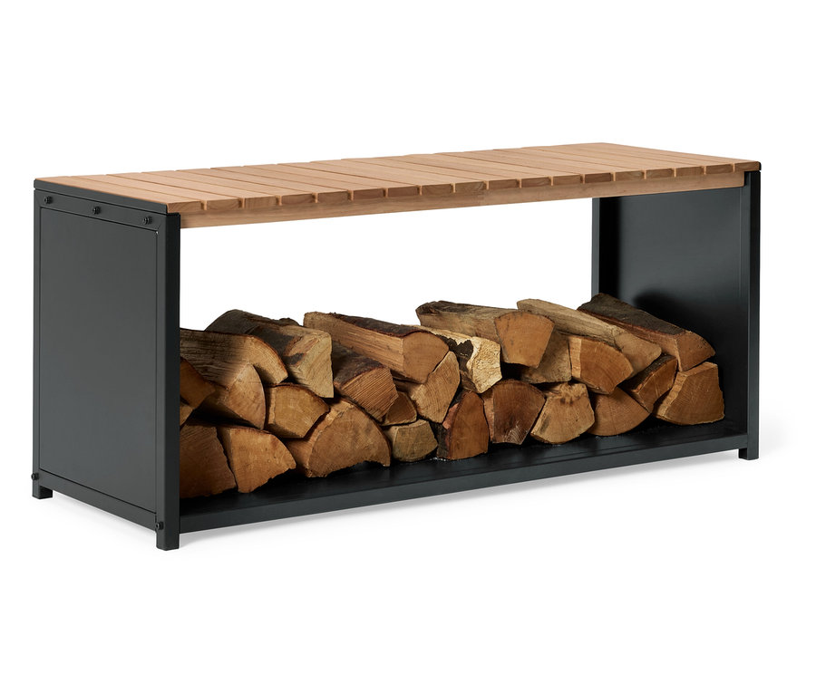 Holzscheite liegen unter einer Bank mit einer Sitzfläche aus Holzlatten und einem anthrazitfarbenen Gestell.