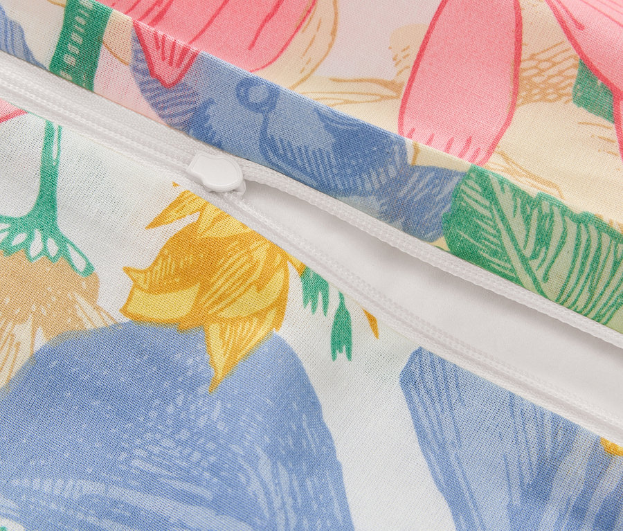 Nahaufnahme eines teilweise geöffneten Reissverschlusses auf einem Kissenbezug mit Blumenmuster.