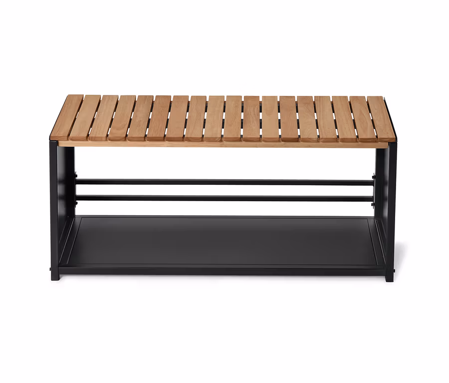 Eine Bank mit einer Sitzfläche aus hellem Holz und einem schwarzen Metallgestell mit einer Ablage.