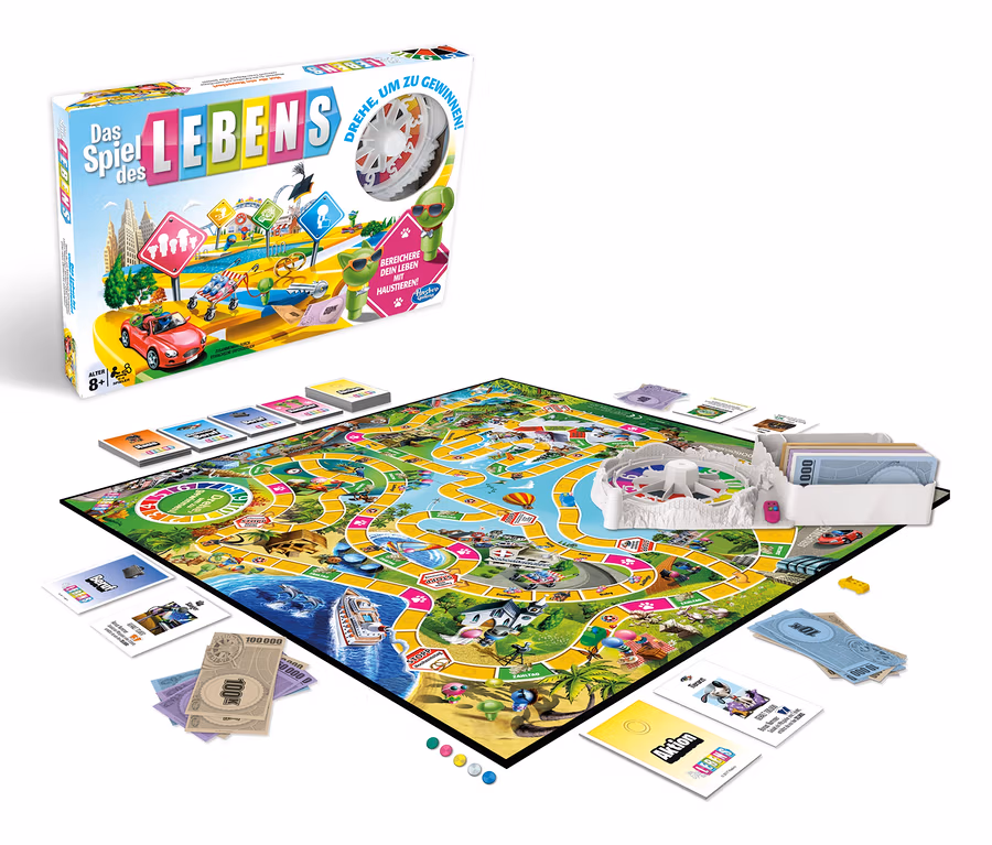 Spielbrett und Schachtel von Hasbro »Das Spiel des Lebens« mit Karten und Spielgeld auf weißem Hintergrund.