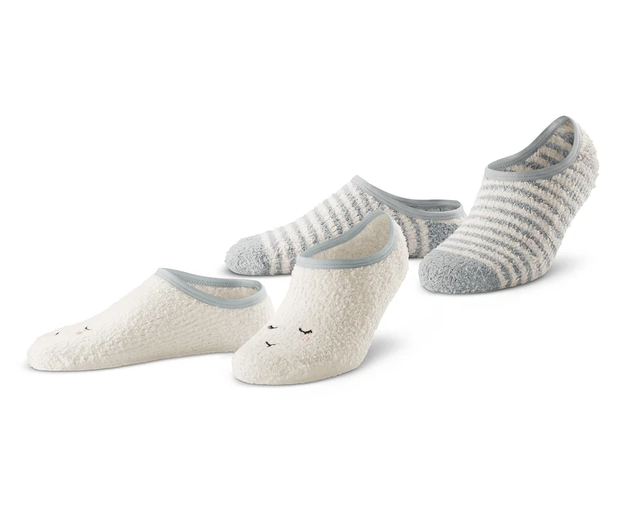 Zwei Paar Hausschuhsocken sind dargestellt. Ein Paar ist weiß mit Gesicht, das andere grau mit weißen Streifen.