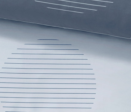 Detail einer Satin-Wendebettwäsche in Normalgröße mit geometrischem Muster.