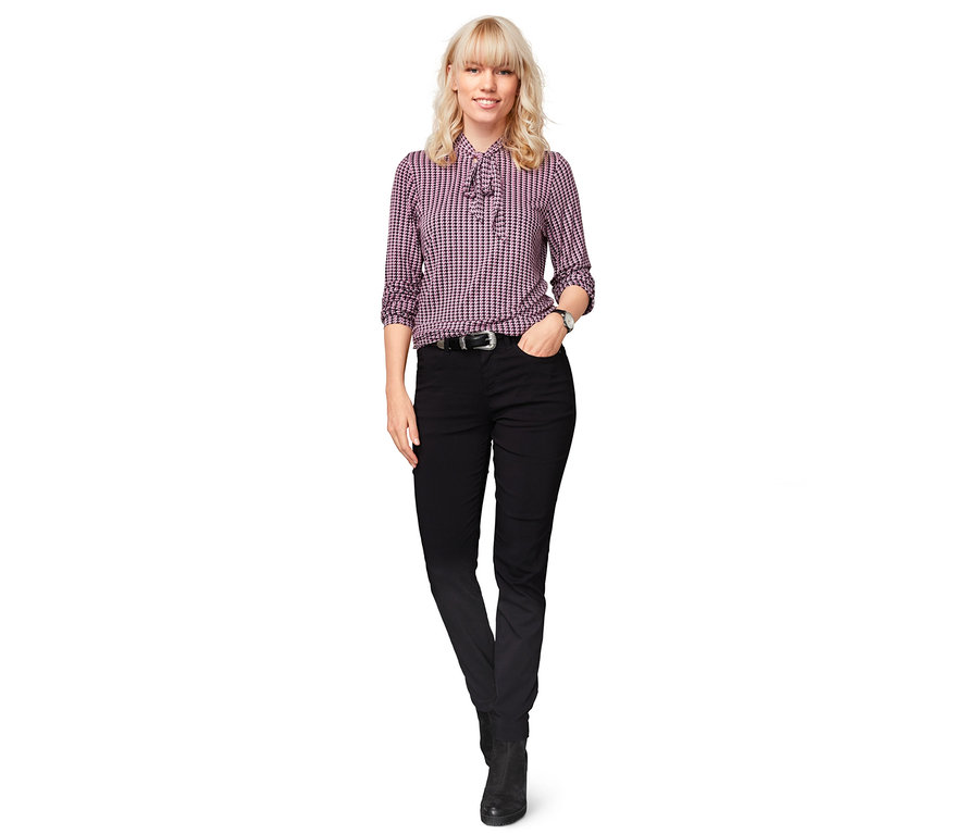 Frau steht und trägt eine schwarze Thermo-Bengalin-Hose.