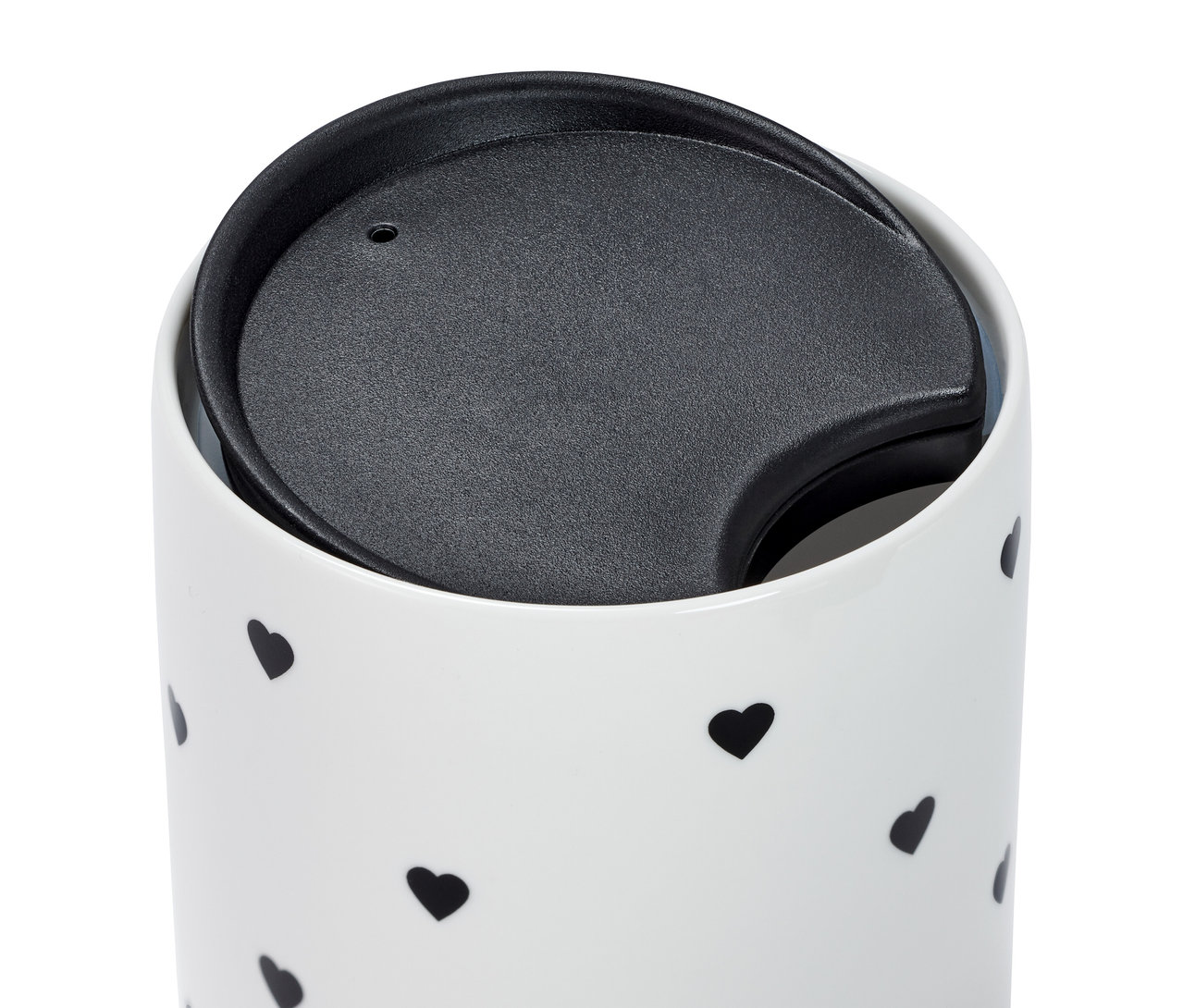 Detailansicht eines Porzellanbechers mit Deckel und schwarzen Herzchen.