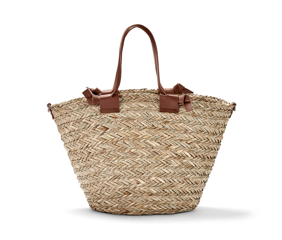 Eine Korbtasche mit braunen Ledergriffen.