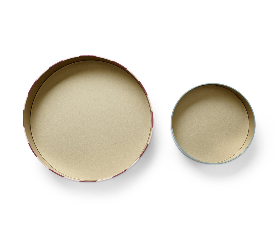 Zwei leere Keksdosen, eine größere mit rot-weißem Streifen, die andere kleinere mit blauem Rand, auf weißem Hintergrund.